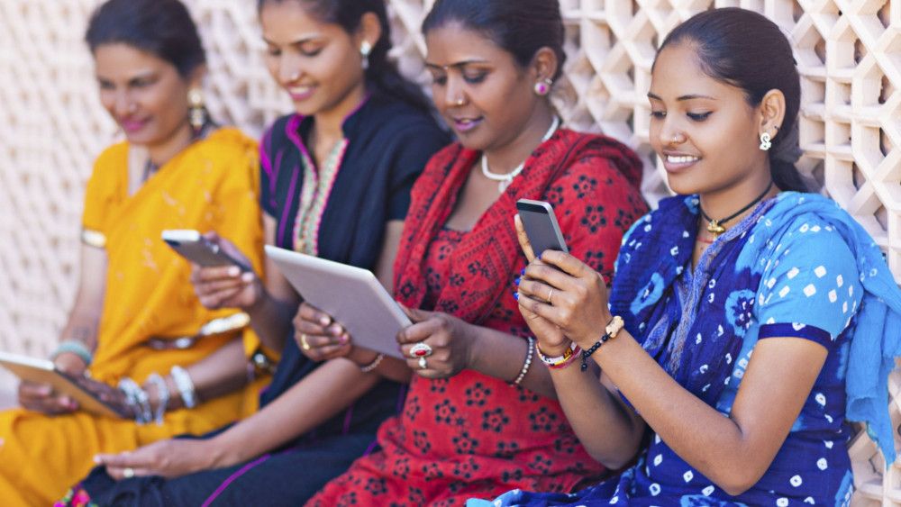 Indian women using their technology to browse for information about Covid barriers for medical facilities.